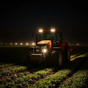 Tractor and farm machinery on a dark field illuminated by modern agricultural LED work lights