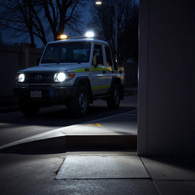 LED safety lights illuminating a vehicle area and marked walkway at dusk for safer night work