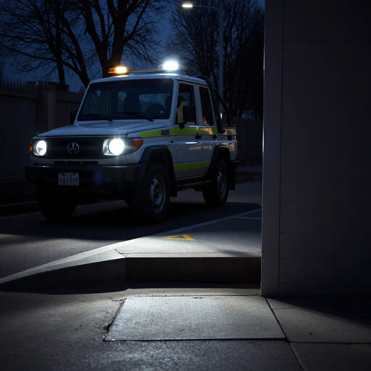 LED safety lights illuminating a vehicle area and marked walkway at dusk for safer night work