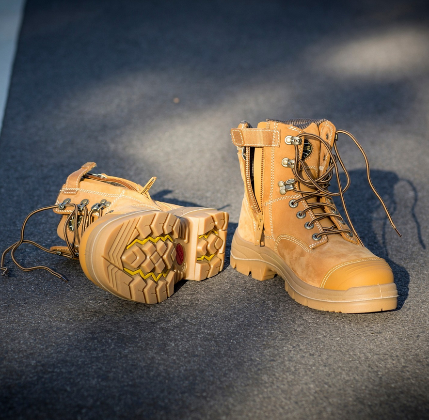 Pair of tan work boots on a dark textured surface